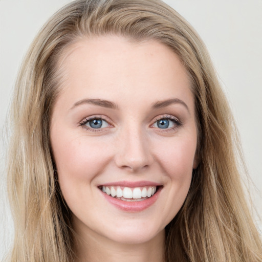 Joyful white young-adult female with long  brown hair and blue eyes