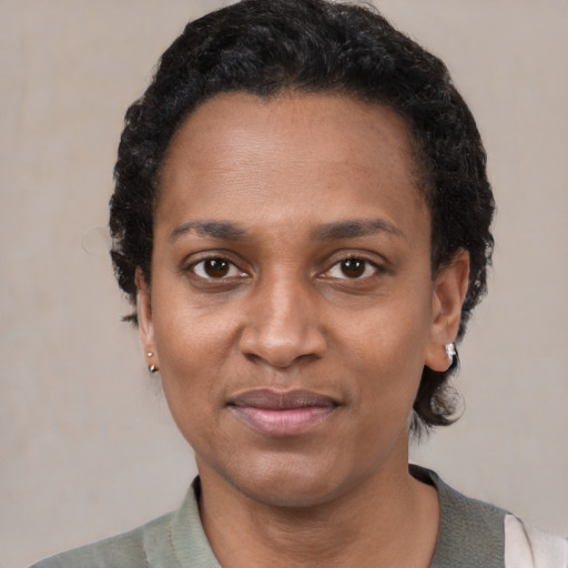 Joyful black adult female with short  black hair and brown eyes