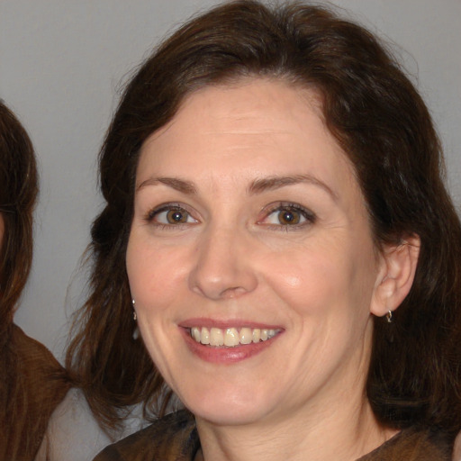 Joyful white adult female with medium  brown hair and brown eyes