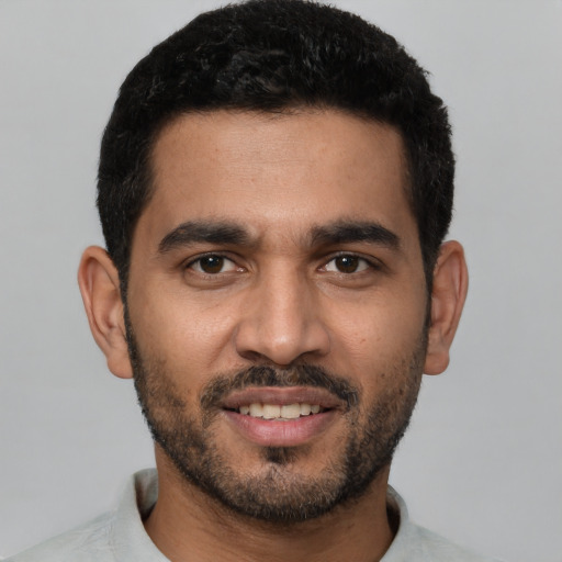 Joyful latino young-adult male with short  black hair and brown eyes