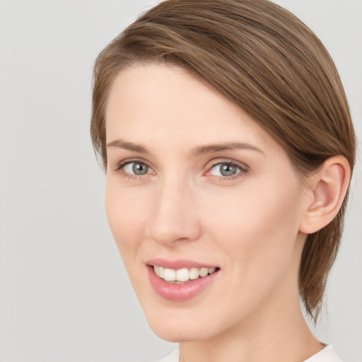 Joyful white young-adult female with medium  brown hair and grey eyes