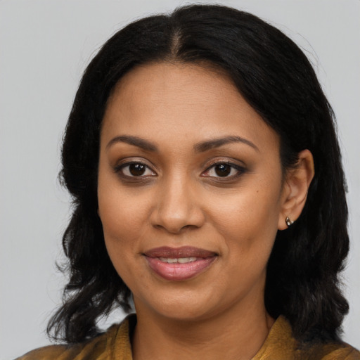 Joyful black adult female with long  black hair and brown eyes