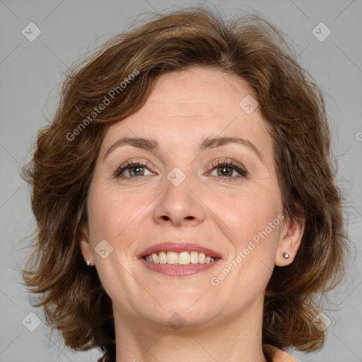 Joyful white adult female with medium  brown hair and green eyes