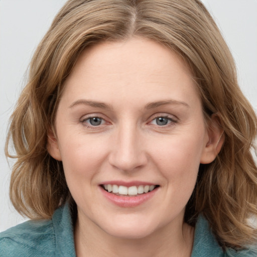 Joyful white young-adult female with medium  brown hair and blue eyes