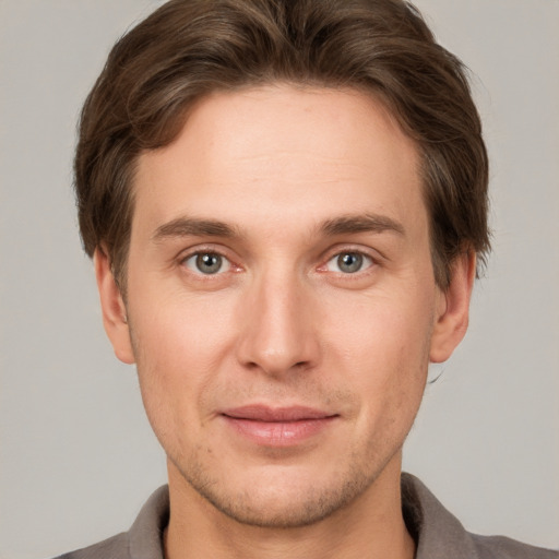 Joyful white young-adult male with short  brown hair and grey eyes