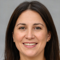 Joyful white adult female with long  brown hair and brown eyes