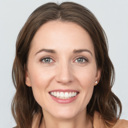 Joyful white young-adult female with medium  brown hair and grey eyes