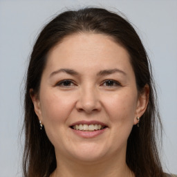 Joyful white adult female with long  brown hair and brown eyes