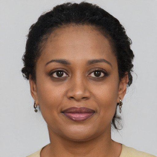 Joyful black young-adult female with long  brown hair and brown eyes