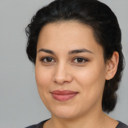 Joyful latino young-adult female with medium  brown hair and brown eyes