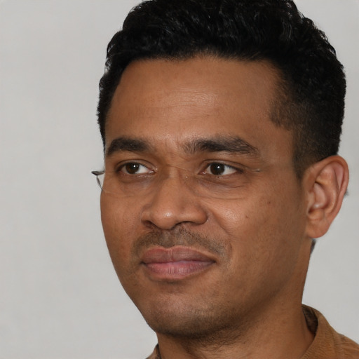 Joyful black young-adult male with short  black hair and brown eyes