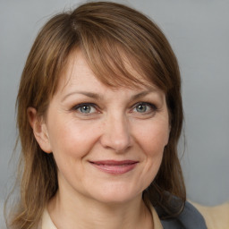 Joyful white adult female with medium  brown hair and grey eyes