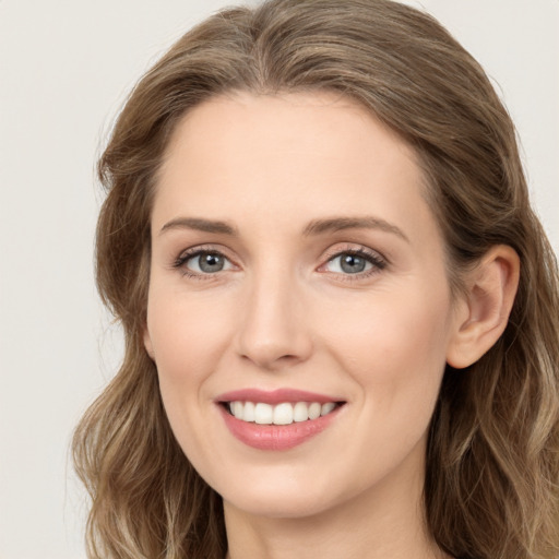 Joyful white young-adult female with long  brown hair and blue eyes