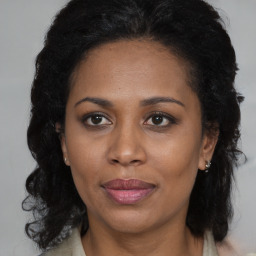 Joyful black adult female with long  brown hair and brown eyes