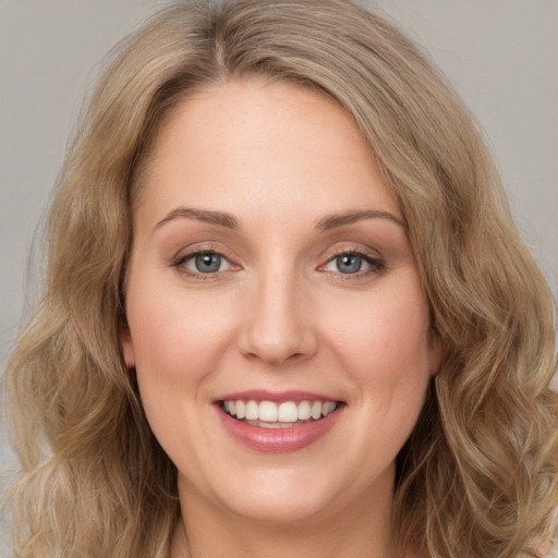 Joyful white young-adult female with long  brown hair and green eyes