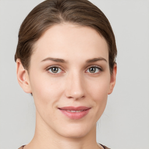 Joyful white young-adult female with short  brown hair and grey eyes