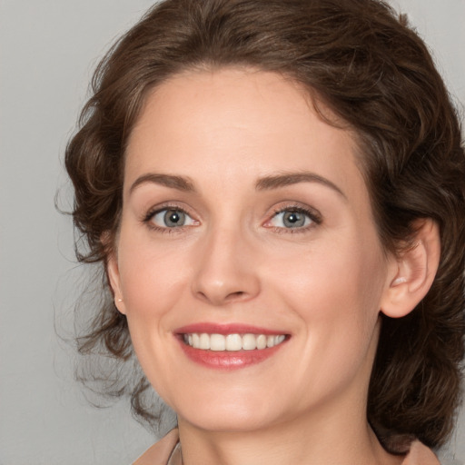 Joyful white young-adult female with medium  brown hair and green eyes