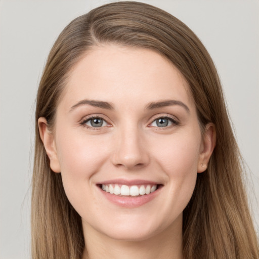 Joyful white young-adult female with long  brown hair and grey eyes