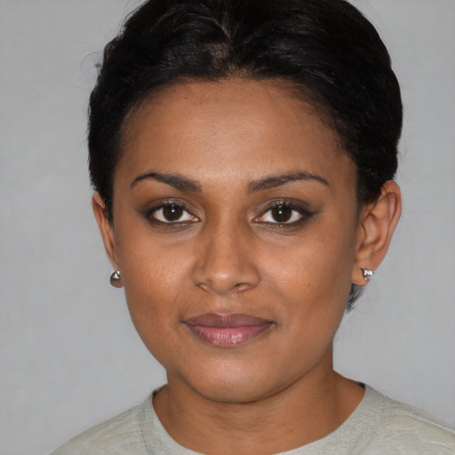 Joyful black young-adult female with short  black hair and brown eyes
