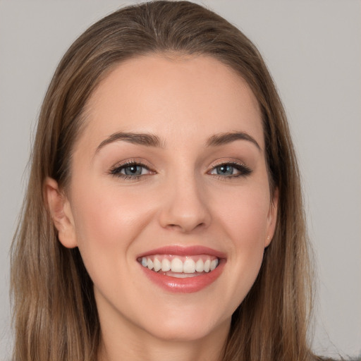 Joyful white young-adult female with long  brown hair and grey eyes