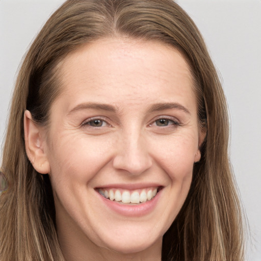 Joyful white young-adult female with long  brown hair and grey eyes