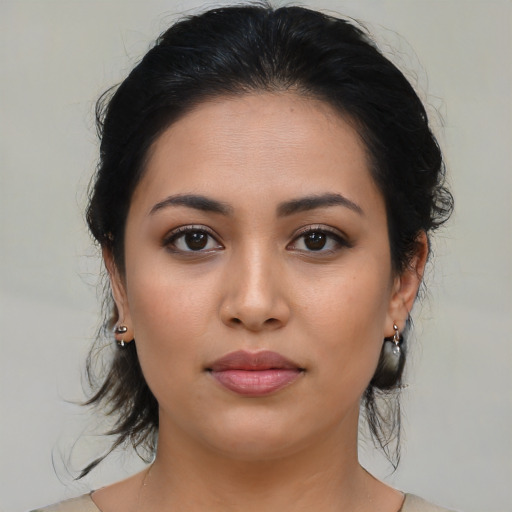 Joyful latino young-adult female with medium  brown hair and brown eyes