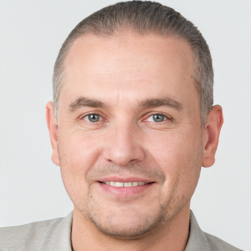 Joyful white adult male with short  brown hair and grey eyes