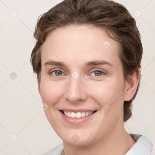 Joyful white young-adult female with short  brown hair and grey eyes