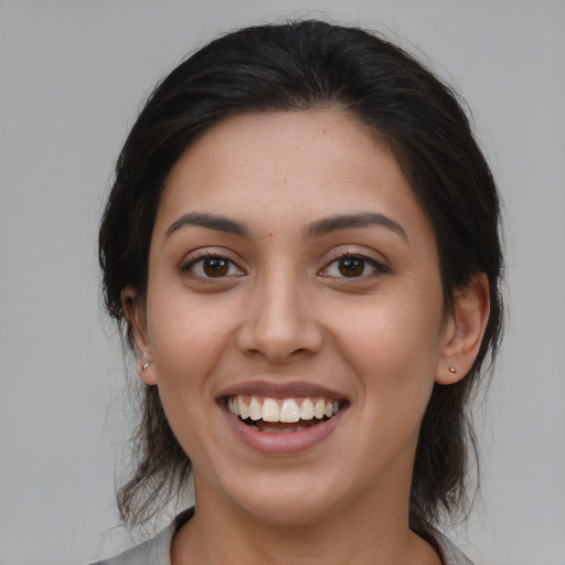 Joyful latino young-adult female with medium  brown hair and brown eyes