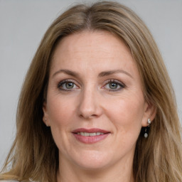 Joyful white adult female with long  brown hair and grey eyes