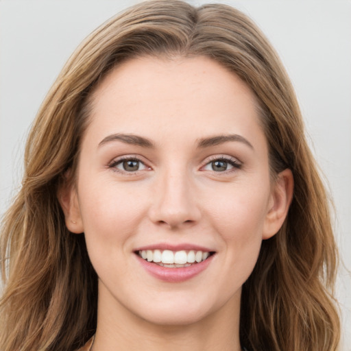 Joyful white young-adult female with long  brown hair and green eyes