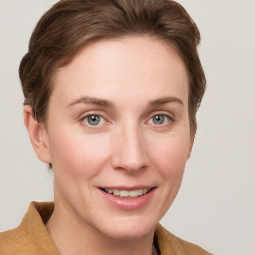 Joyful white young-adult female with short  brown hair and grey eyes