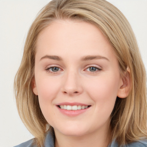 Joyful white young-adult female with medium  brown hair and blue eyes