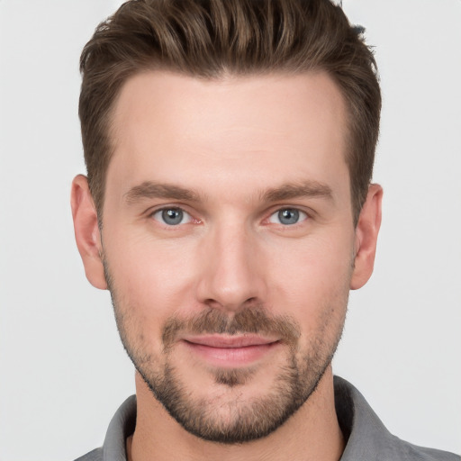 Joyful white young-adult male with short  brown hair and grey eyes