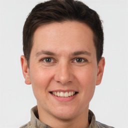 Joyful white young-adult male with short  brown hair and grey eyes