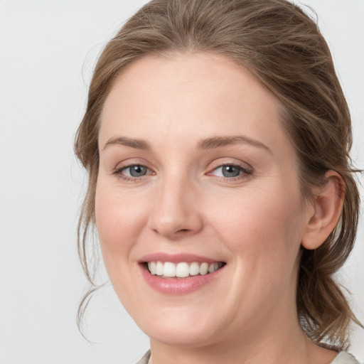 Joyful white young-adult female with medium  brown hair and blue eyes