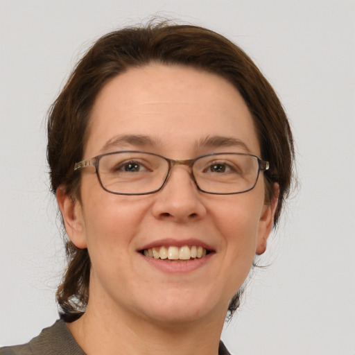 Joyful white adult female with medium  brown hair and grey eyes