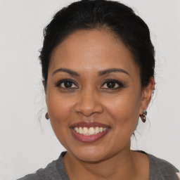 Joyful latino young-adult female with medium  brown hair and brown eyes