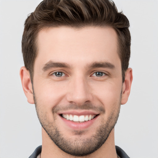 Joyful white young-adult male with short  brown hair and grey eyes