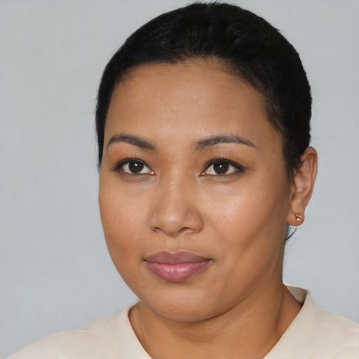 Joyful latino young-adult female with short  black hair and brown eyes