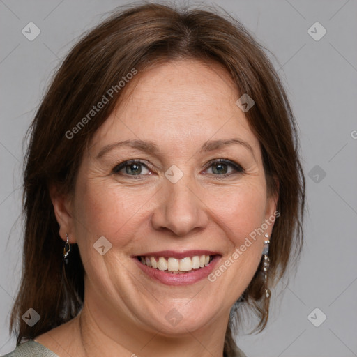 Joyful white adult female with medium  brown hair and blue eyes