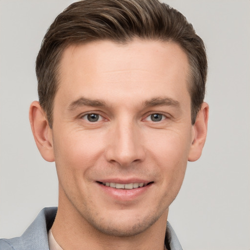 Joyful white young-adult male with short  brown hair and grey eyes