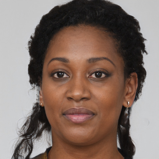 Joyful black young-adult female with long  black hair and brown eyes
