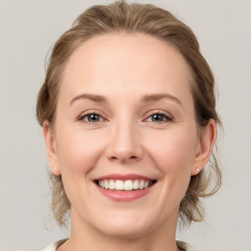 Joyful white young-adult female with medium  brown hair and grey eyes