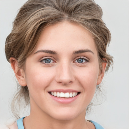 Joyful white young-adult female with medium  brown hair and blue eyes