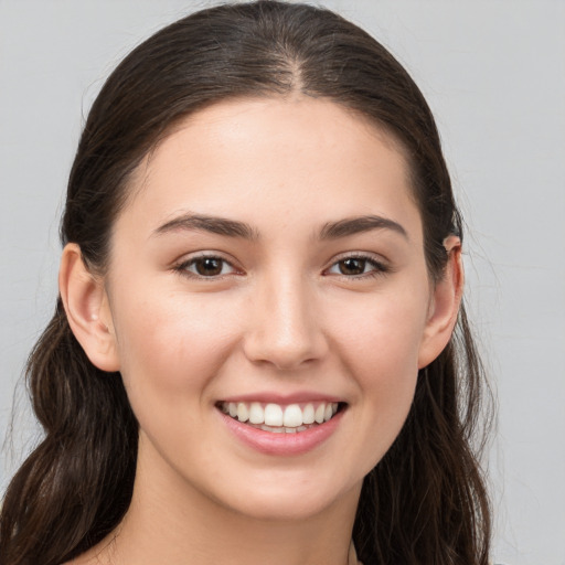 Joyful white young-adult female with long  brown hair and brown eyes