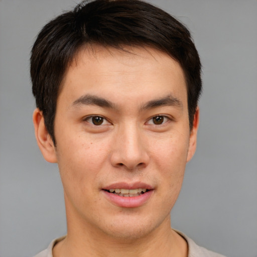 Joyful asian young-adult male with short  brown hair and brown eyes