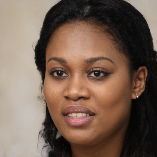 Joyful black young-adult female with long  black hair and brown eyes