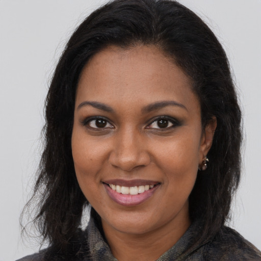 Joyful black young-adult female with long  brown hair and brown eyes
