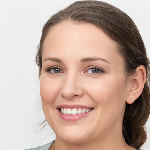 Joyful white young-adult female with medium  brown hair and grey eyes